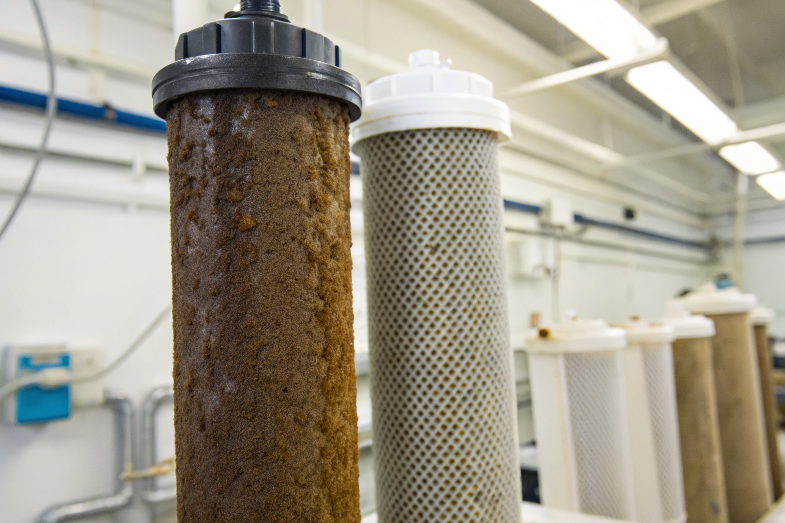 Sediment and carbon filters with sediment buildup in a lab setting.